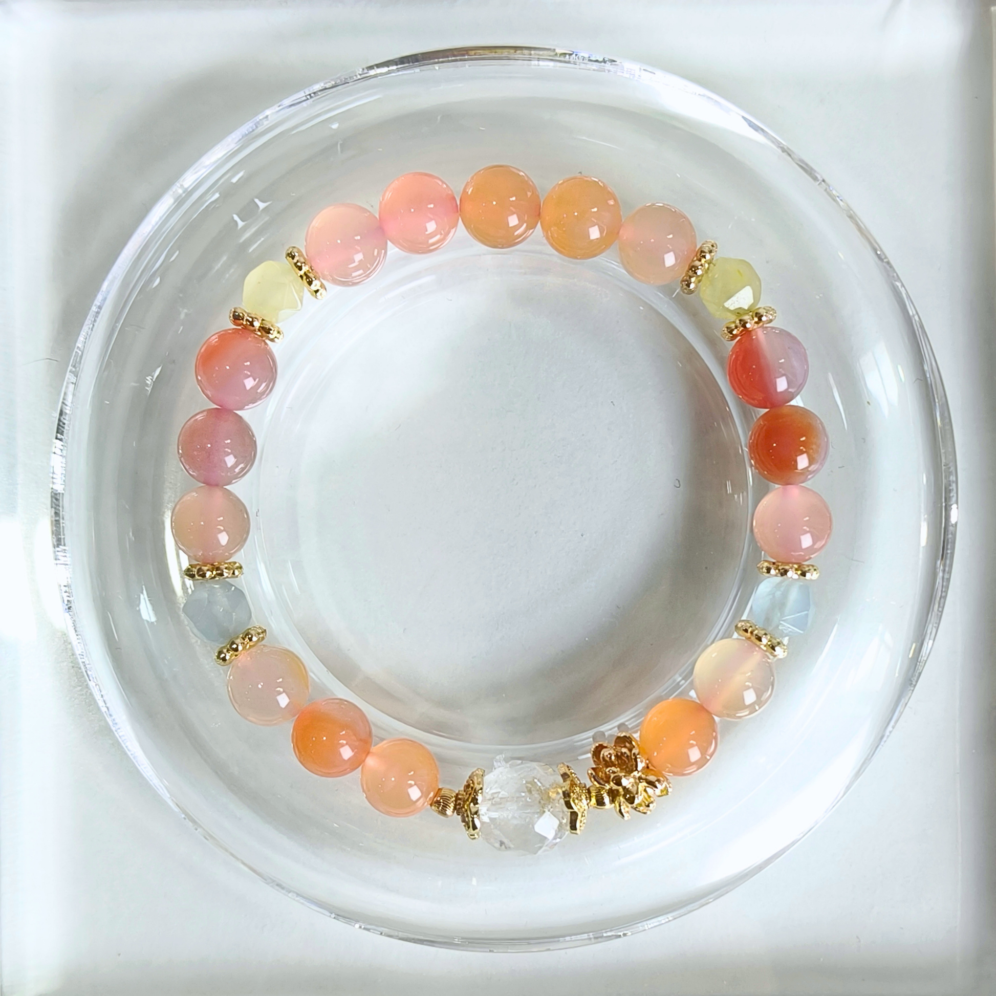A beaded stretch bracelet with round yanyuan agate, chalcedony and clear quartz separated by small gold spacer