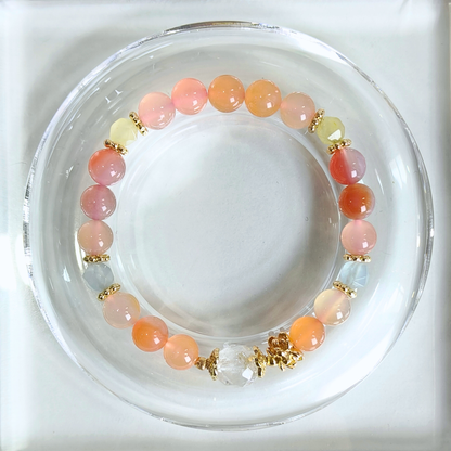 A beaded stretch bracelet with round yanyuan agate, chalcedony and clear quartz separated by small gold spacer